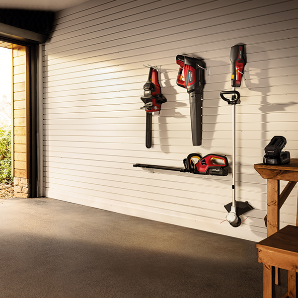 In einer Garage hängen Honda Akku-Gartengeräte an der Wand.
